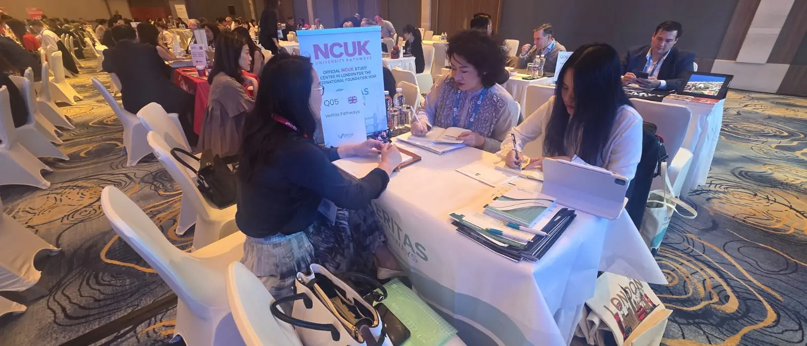 Attendees seated at round tables at the NCUK official study centre conference