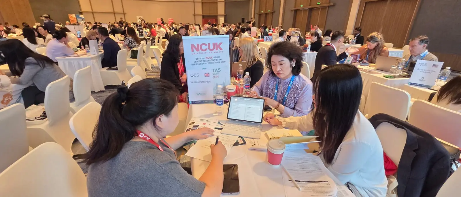 Wide view of delegates at round tables, NCUK official study centre conference
